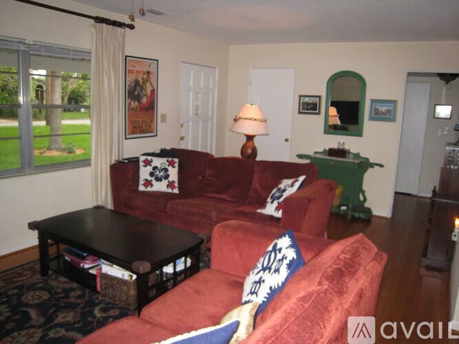 A living room with a red couch and a black coffee table.