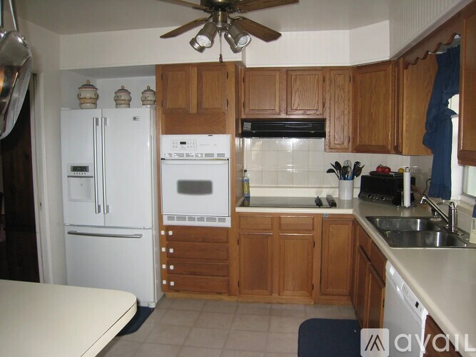 A kitchen with wooden cabinets and white appliances.