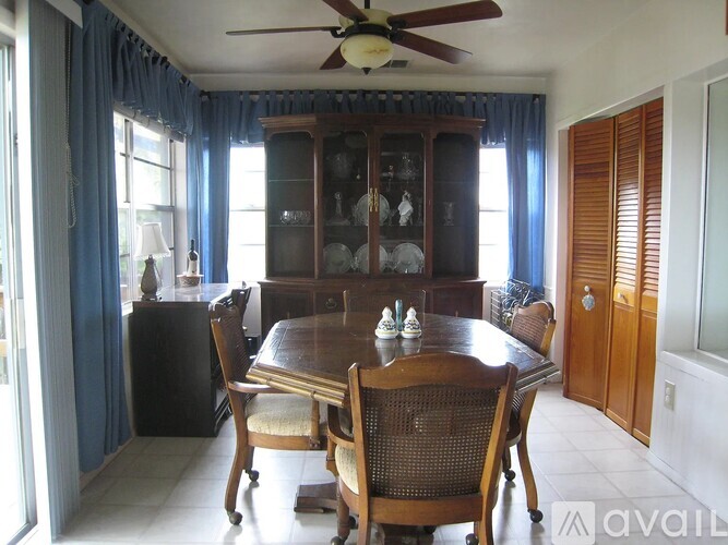 A dining room with a wooden table and chairs.