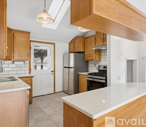A kitchen with wooden cabinets and a white countertop.