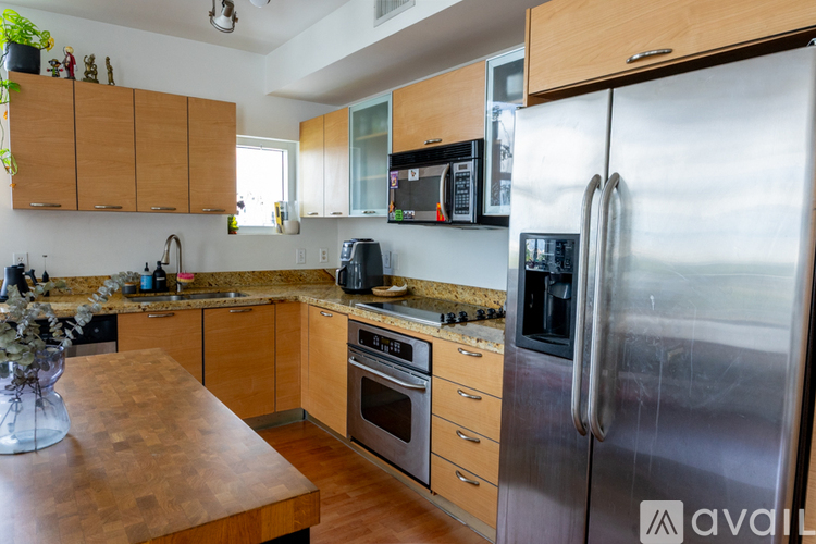 A kitchen with wooden cabinets and a stainless steel refrigerator.
