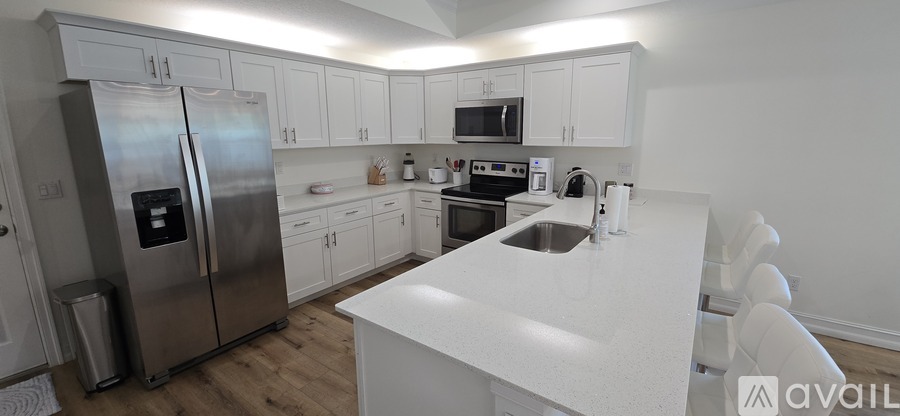 A kitchen with white cabinets and a white island.