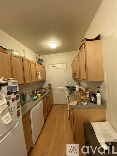 A kitchen with wooden cabinets and a white fridge.