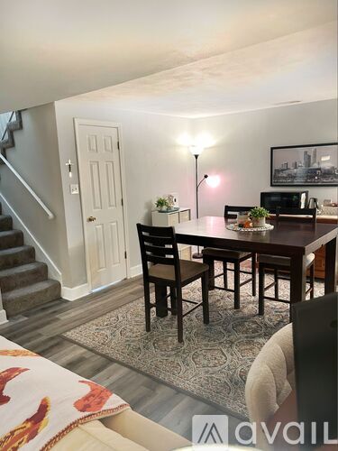 A dining room with a table and chairs.