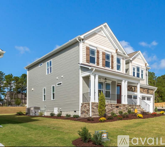 A house with a front yard and a clear blue sky.