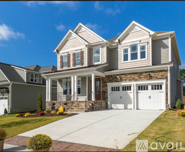 A two-story house with a garage and a driveway.