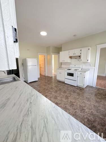 A kitchen with white appliances and a countertop.