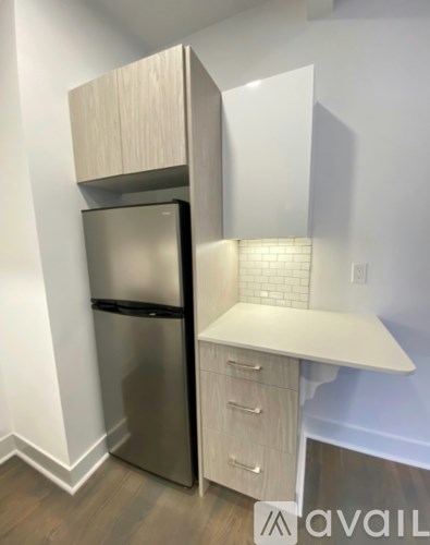 A kitchen with a stainless steel refrigerator and a white countertop.