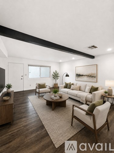 A living room with a white couch, a wooden coffee table, and a large painting on the wall.