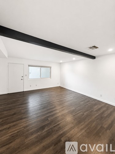 A room with wooden flooring and a white door.