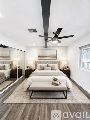 A bedroom with a large bed and a ceiling fan.
