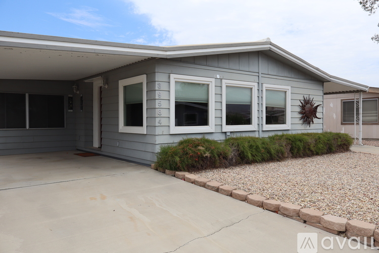 A house with a grey exterior and a gravel driveway.