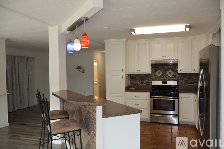 A kitchen with a white counter and a stove top oven.