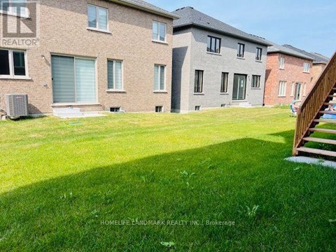 A grassy area in front of a brick building with a sign that says "REALTOR".