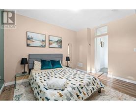 A bedroom with a large bed and two lamps.