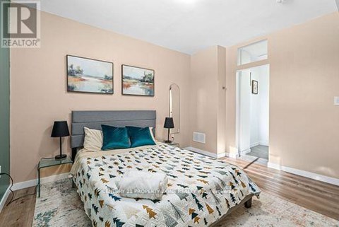 A bedroom with a large bed and two lamps.