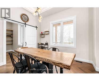 A dining room with a wooden table and chairs.