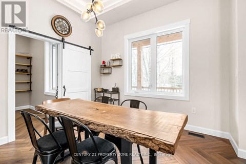 A dining room with a wooden table and chairs.