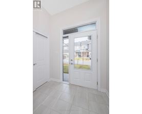 A white door with a glass window is in a room with white walls.