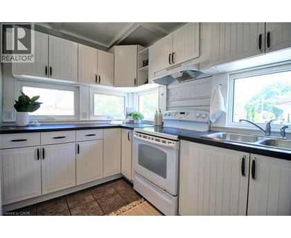 A kitchen with white cabinets and a black countertop.