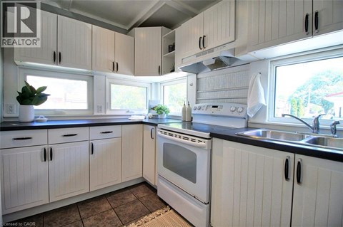 A kitchen with white cabinets and a black countertop.
