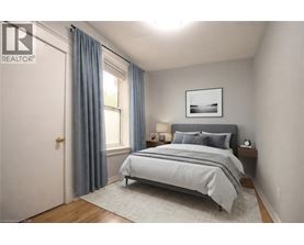 A bedroom with a bed, nightstand, and window.