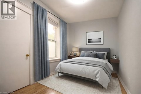 A bedroom with a bed, nightstand, and window.