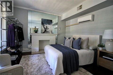A bedroom with a large bed and a fireplace.