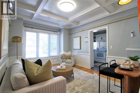 A living room with a couch, a coffee table, and a dining table.