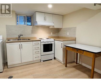 A kitchen with white cabinets and a wooden table.