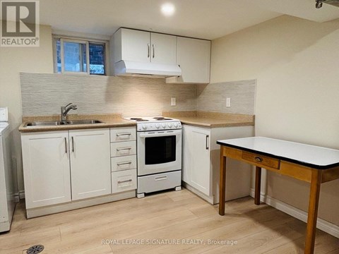 A kitchen with white cabinets and a wooden table.