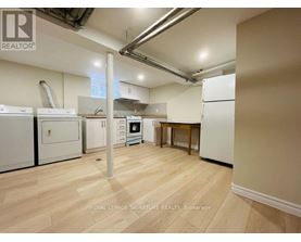 A kitchen area with white appliances and wooden flooring.