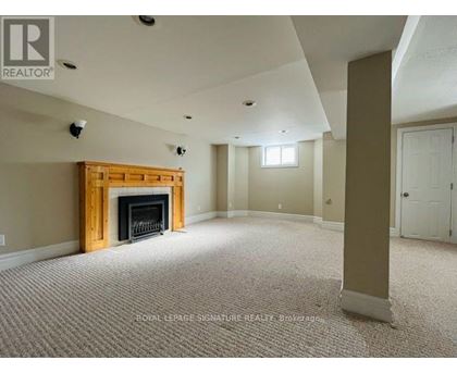 A living room with a fireplace and carpeted floor.