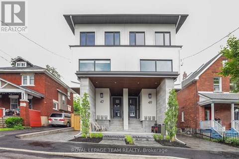 A white two-story house with a balcony on the second floor is for sale.