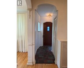 A hallway with a wooden floor and a white column.