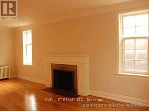 A room with a fireplace and a window.