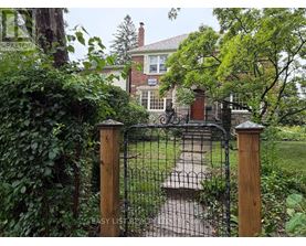 A black wrought iron gate with a wooden post on either side.