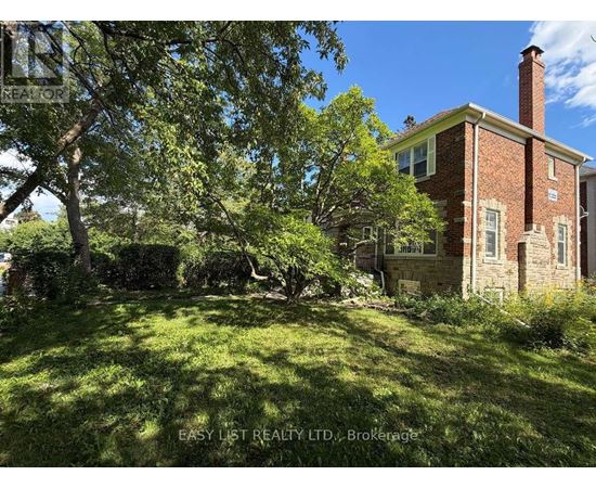 A red brick house with a chimney and a green lawn in front.
