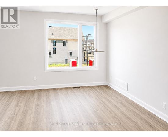 A room with a large window showing a view of a building and a street.