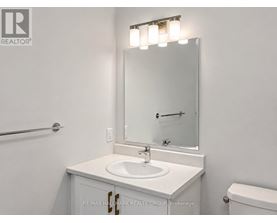 A white sink is under a mirror in a bathroom.
