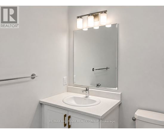A white sink is under a mirror in a bathroom.