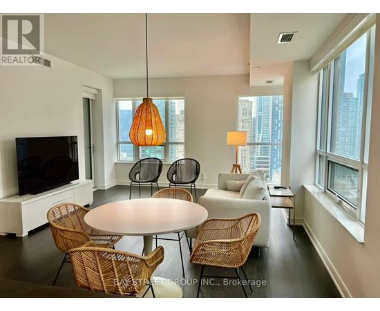A living room with a white table and chairs, a television, and a large window.