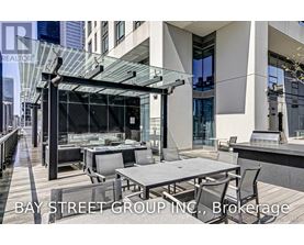 A modern outdoor dining area with a glass roof and a view of the city.