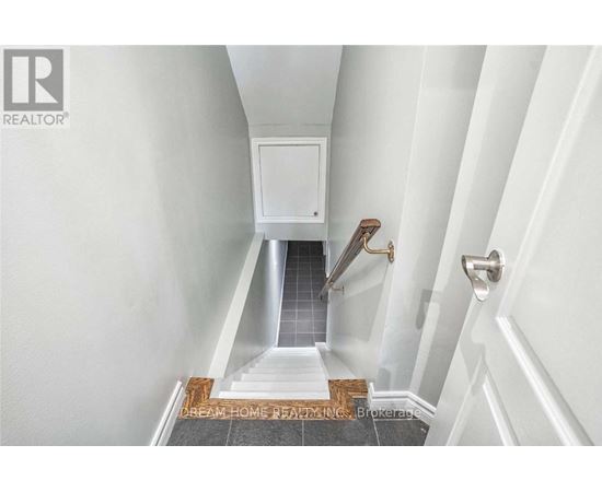 A hallway with a white door and a tiled floor.