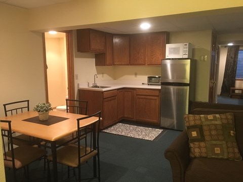 A kitchen with a table and chairs in front of it.