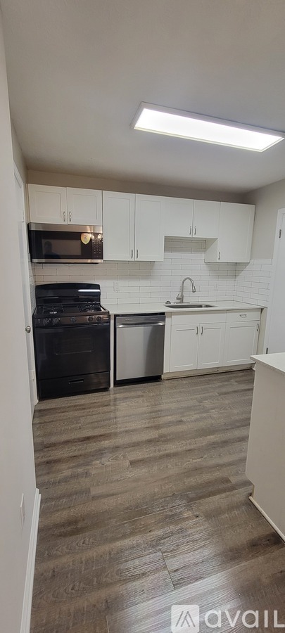 A kitchen with white cabinets and a black oven.