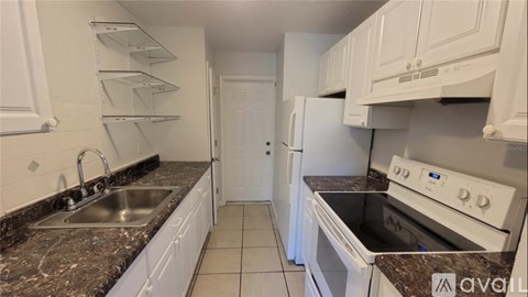A kitchen with white cabinets and a granite countertop.