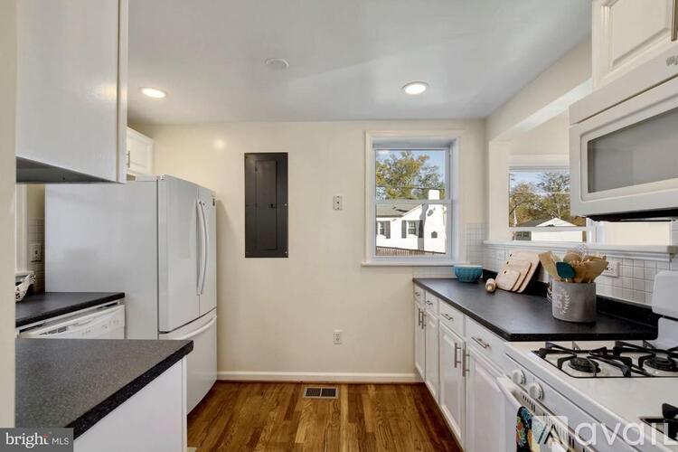 A kitchen with white cabinets and a black countertop.