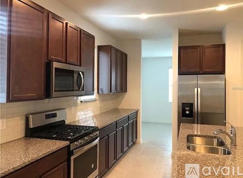 A kitchen with brown cabinets and a granite countertop.