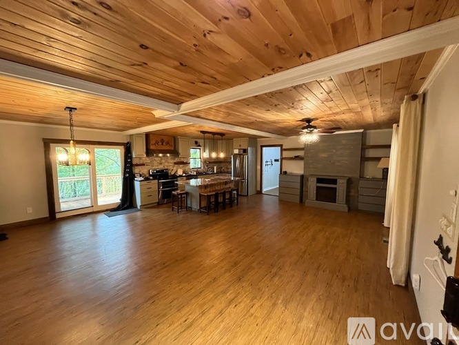A spacious room with wooden floors and a high ceiling.